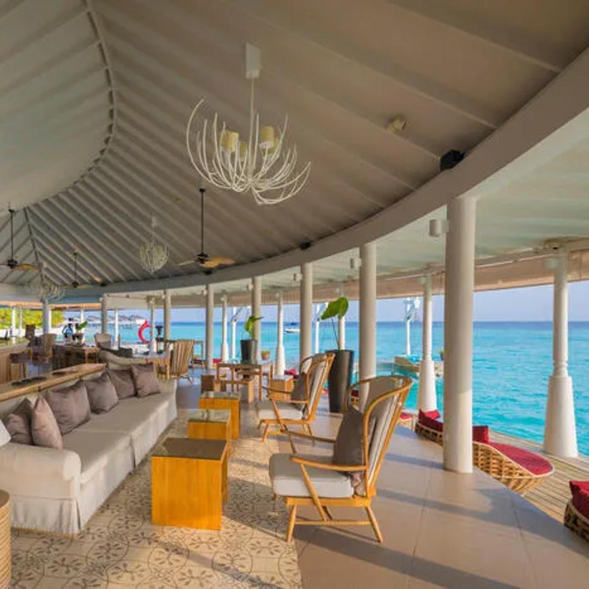 Aqua Bar's open-air lounge deck at the arrival pavilion, seating looking out over the lagoon