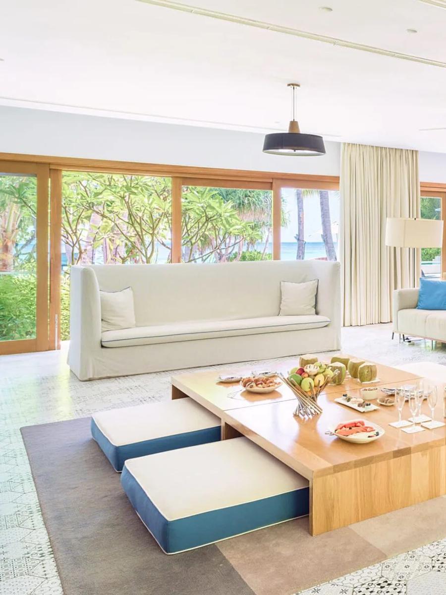 The Great Beach Residence at Amilla seen through the palms, its two wings set either side of a shared pool