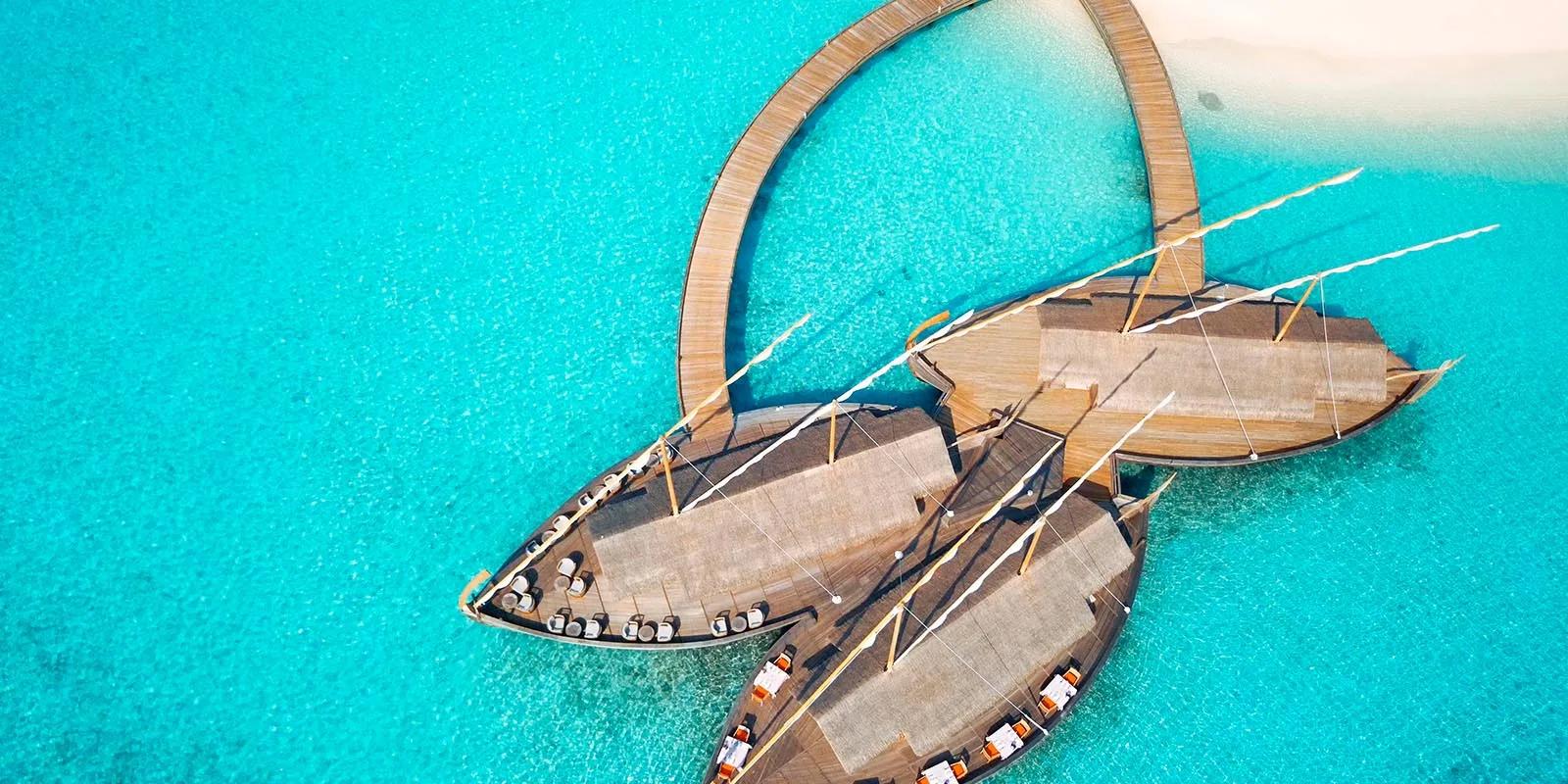 Ba'theli by the Reef at dusk, its pavilions styled after traditional cargo boats floating by the reef.