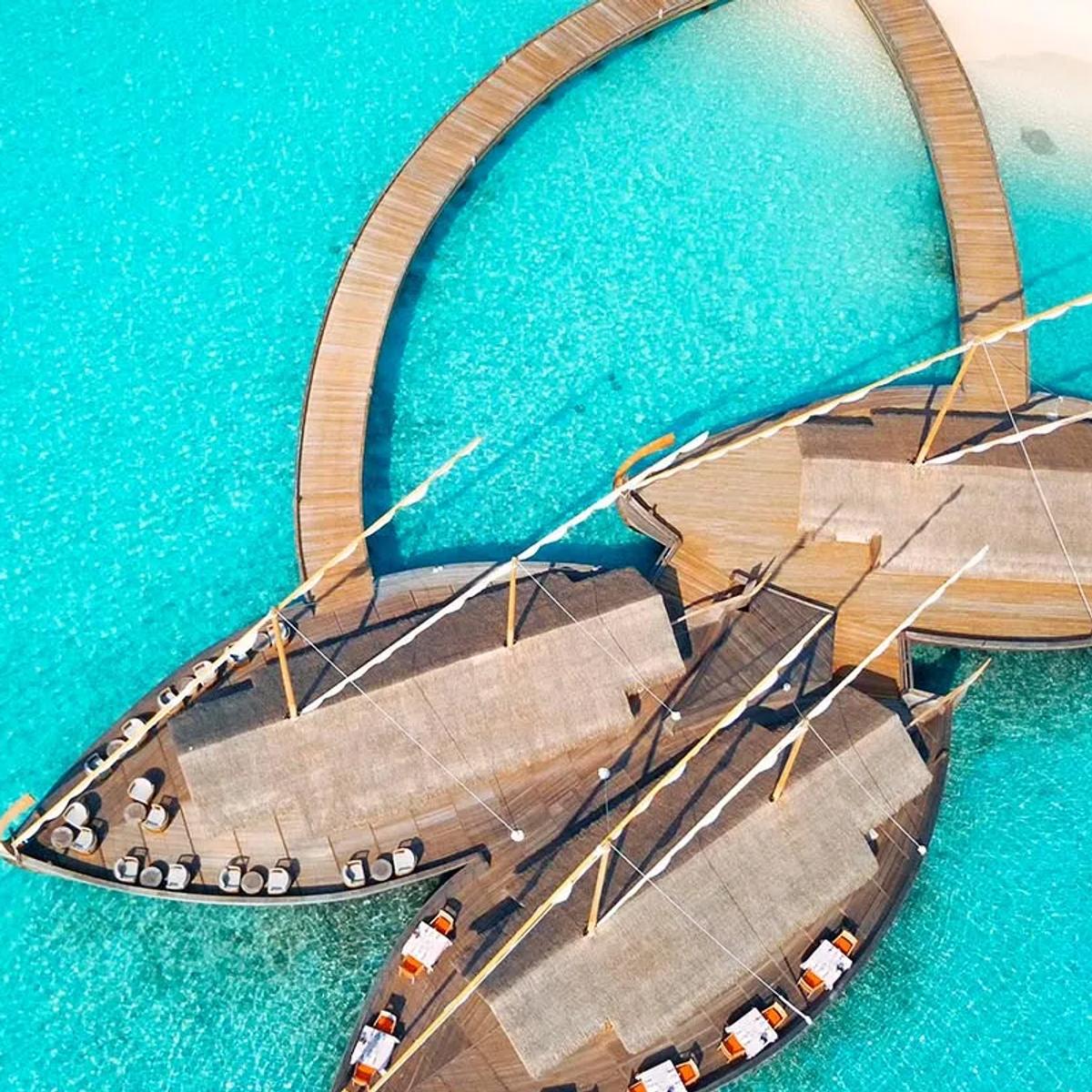 Ba'theli by the Reef at dusk, its pavilions styled after traditional cargo boats floating by the reef.