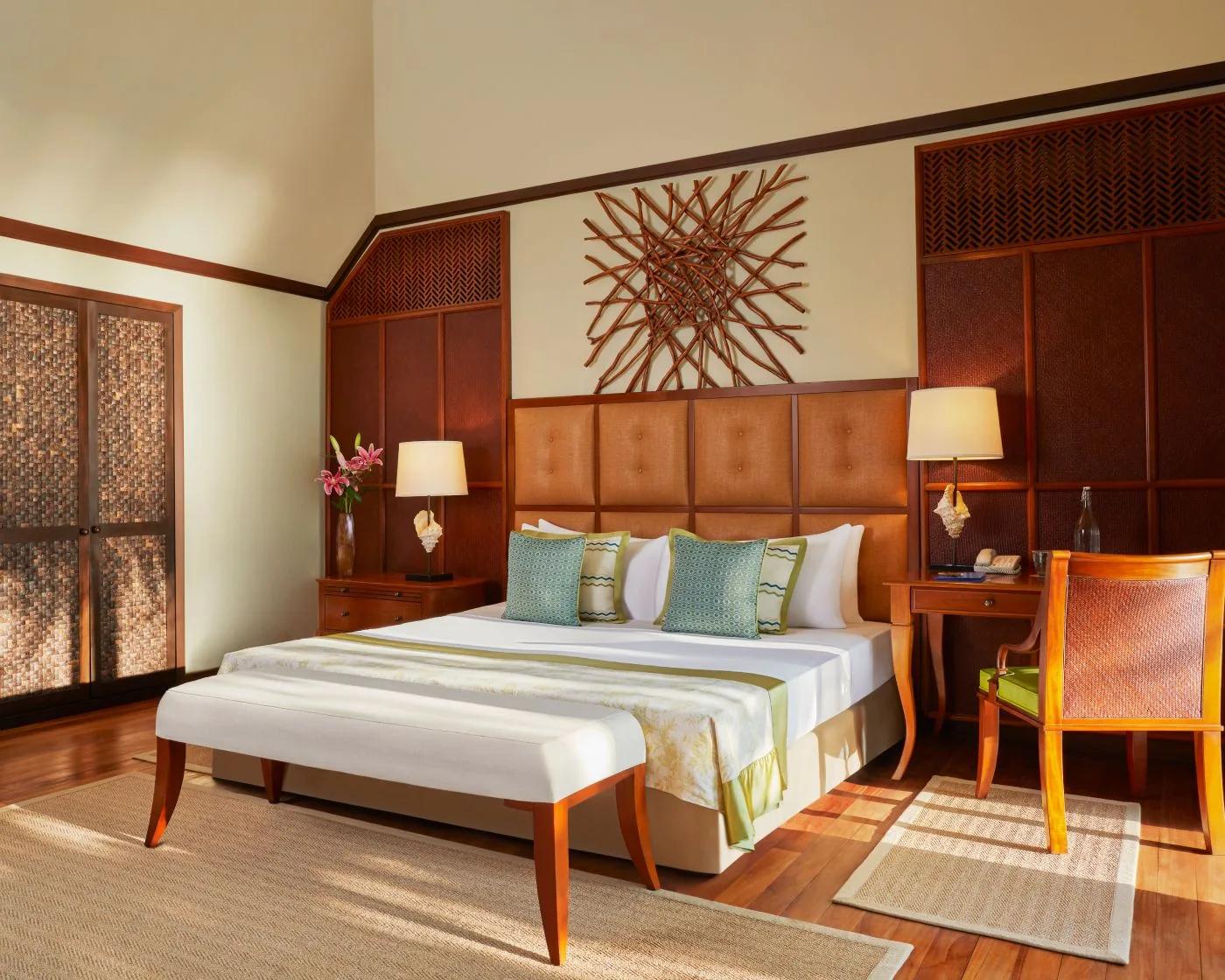 A Two Bedroom Sunset Beachfront Suite's bedroom, a woven twig wall sculpture above the headboard