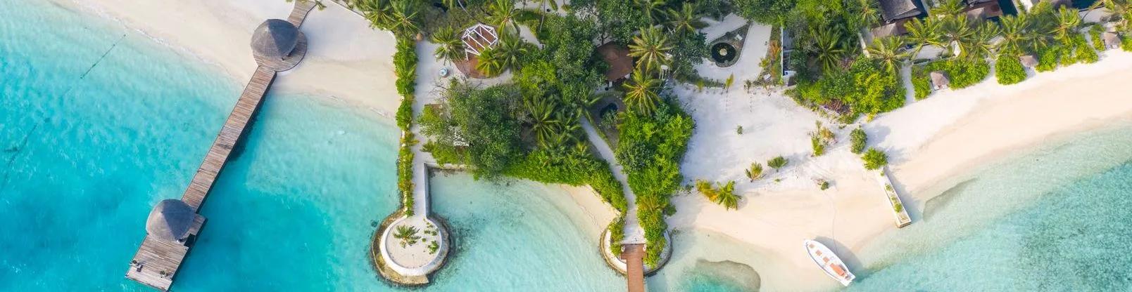 Top-down aerial of Bolifushi Island's beach, jetty and palm-covered grounds meeting the reef