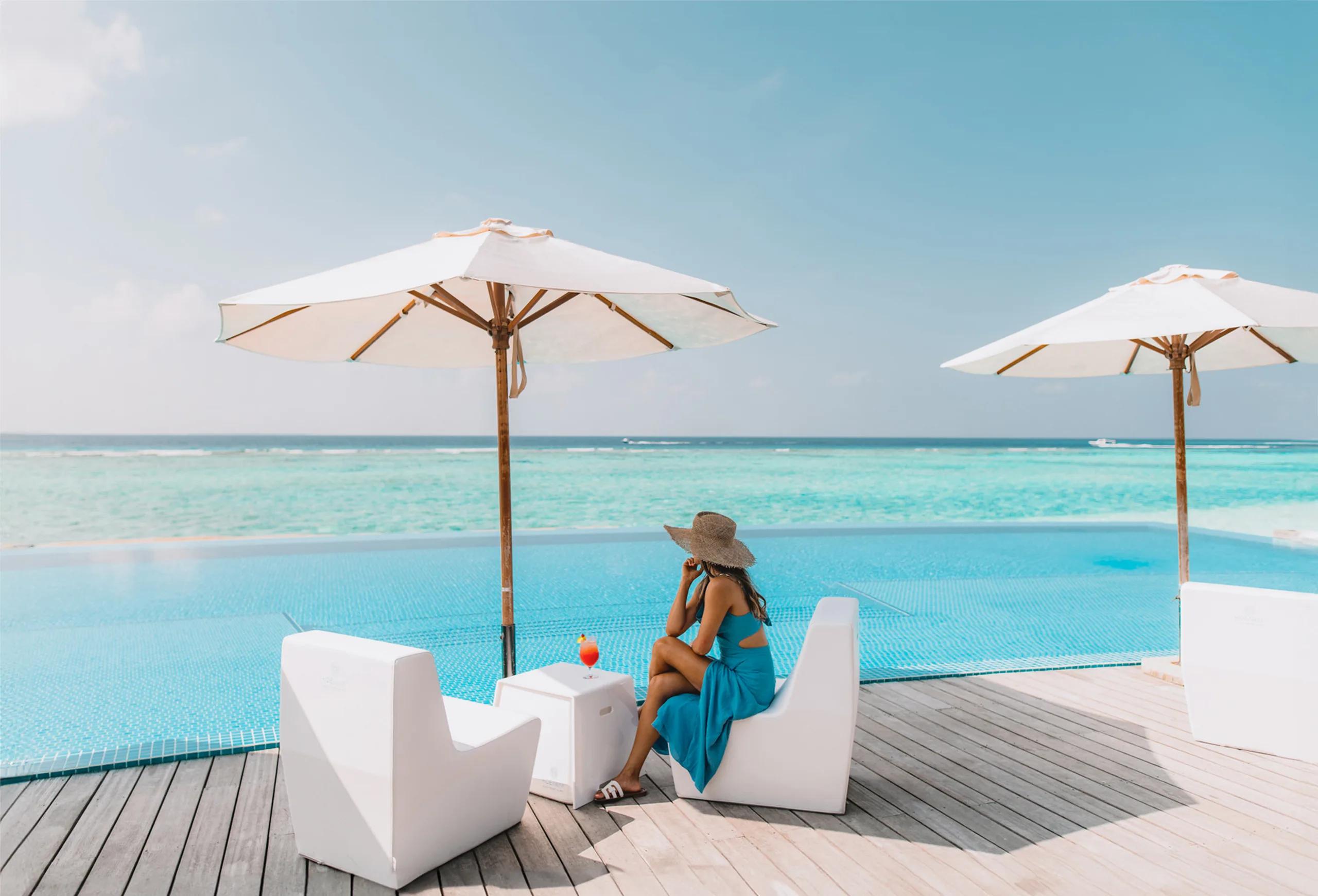 A guest relaxing poolside at Sunset Pool Café, Hideaway Beach Resort & Spa