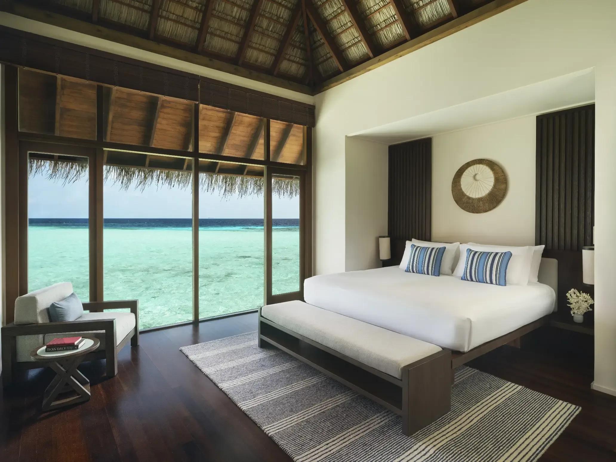 The bedroom of a Grand Water Villa opening onto the lagoon at Conrad Maldives Rangali