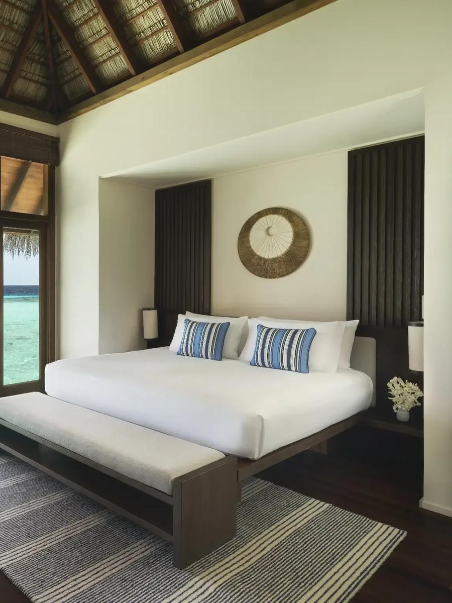The bedroom of a Grand Water Villa opening onto the lagoon at Conrad Maldives Rangali
