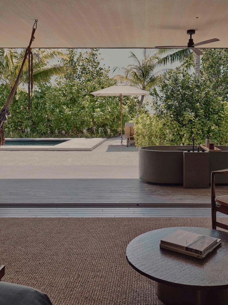 A shaded terrace, outdoor tub, and private pool at a Two-Bedroom Beach Pool Villa, framed by tropical planting