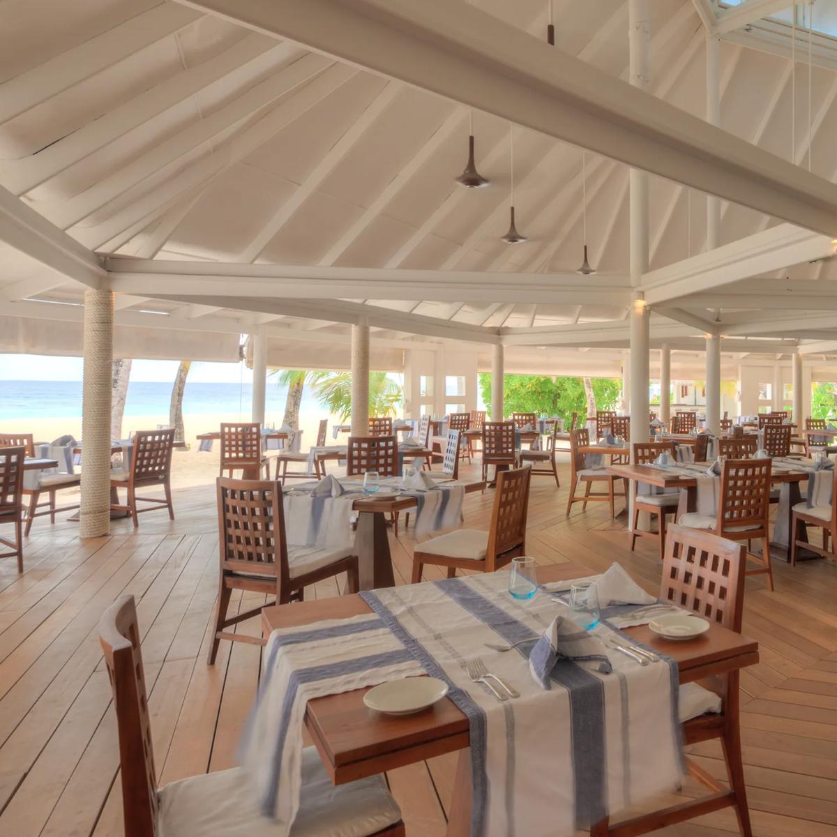 Open-air interior of Maakeyn Buffet Restaurant at Diamonds Athuruga, beach visible beyond