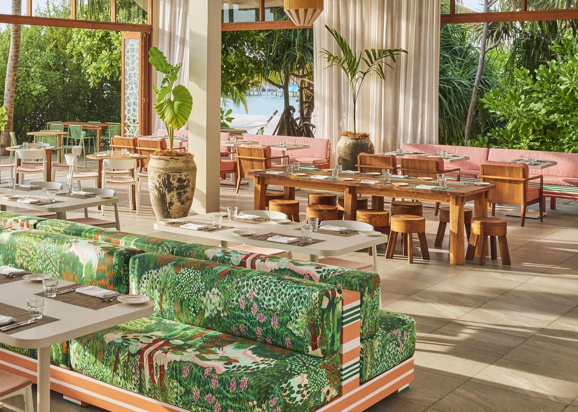 Kula's bright, open-air dining room at The Standard, patterned banquettes and tables set beneath a peaked roof