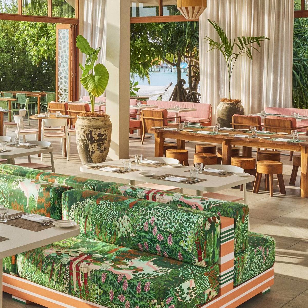Kula's bright, open-air dining room at The Standard, patterned banquettes and tables set beneath a peaked roof