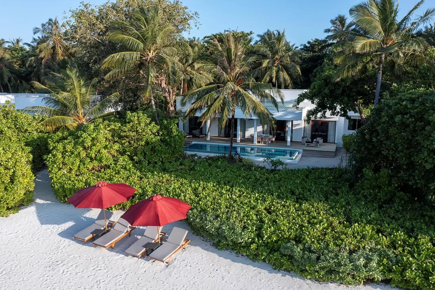 The private pool and dining pergola of the Two-Bedroom Dhigali Suite, palm trees framing the view