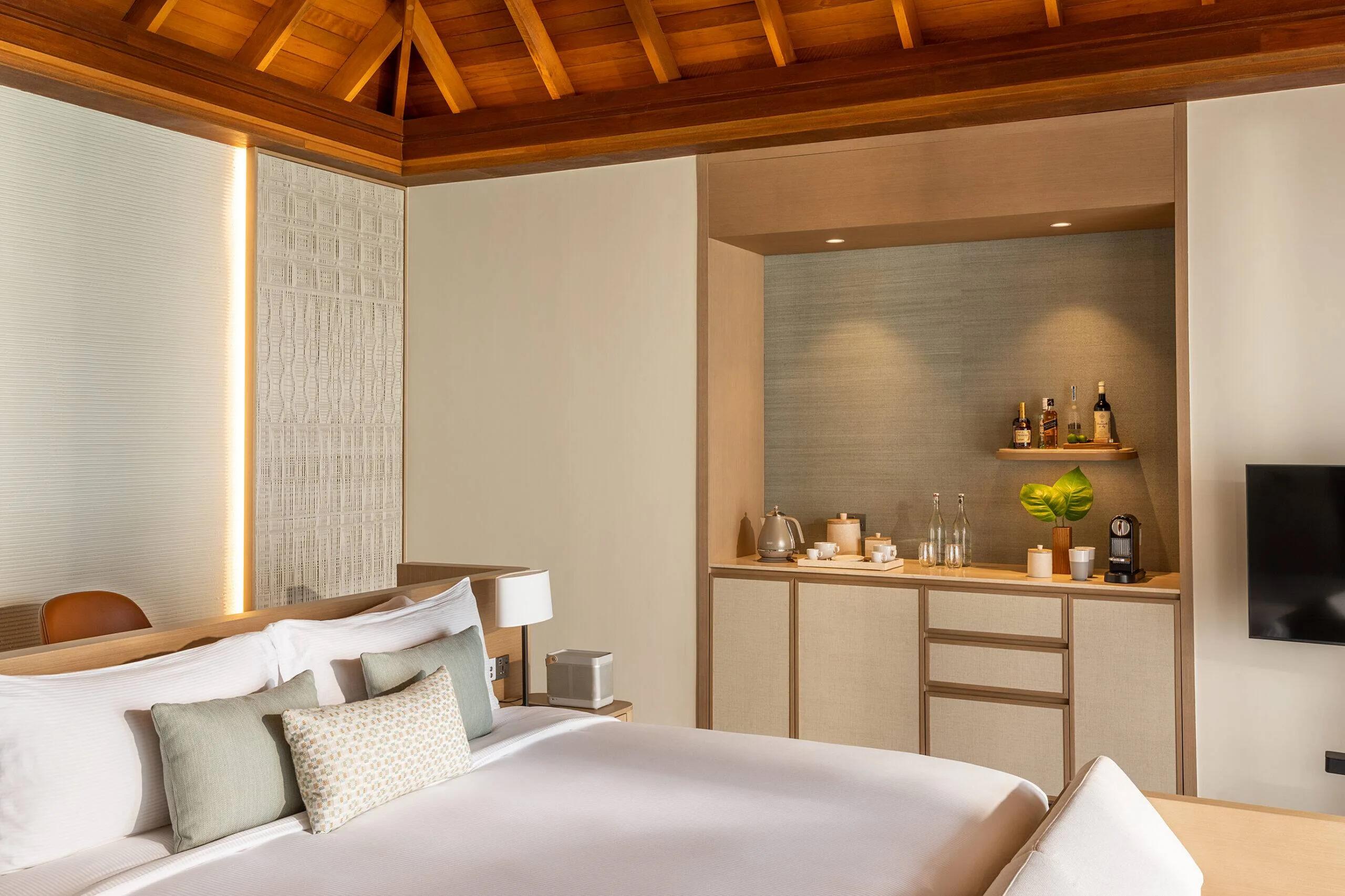 The bedroom and drinks nook inside a Lagoon Bungalow with Pool
