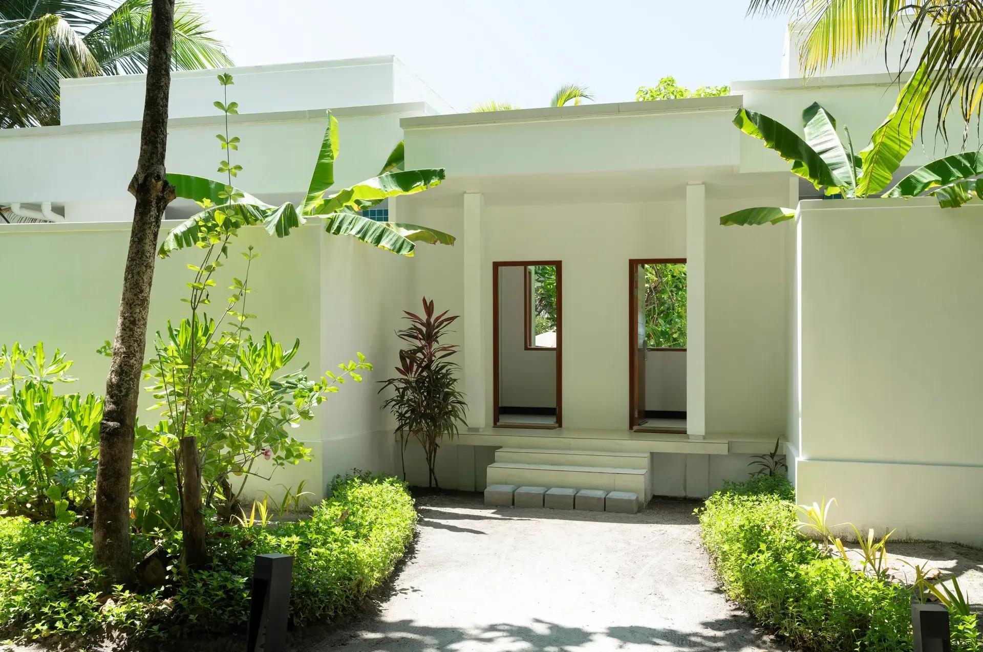 The garden entrance path to a Two-Bedroom Deluxe Beach Bungalow, framed by tropical foliage