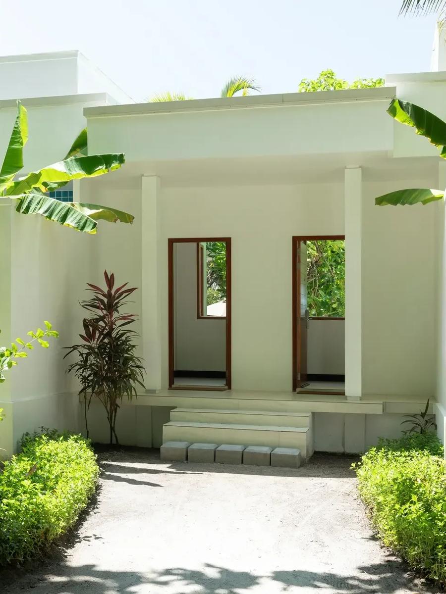 The garden entrance path to a Two-Bedroom Deluxe Beach Bungalow, framed by tropical foliage