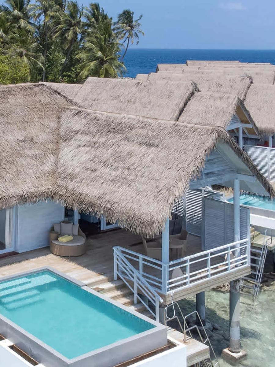 The row of Over Water Suites with Private Pool, thatched roofs stepping out over the lagoon