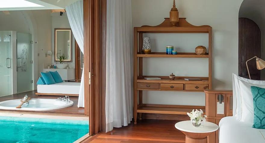 Bedroom of a Sunset Over Water Pool Villa at Anantara Kihavah, with a pool and bathroom view