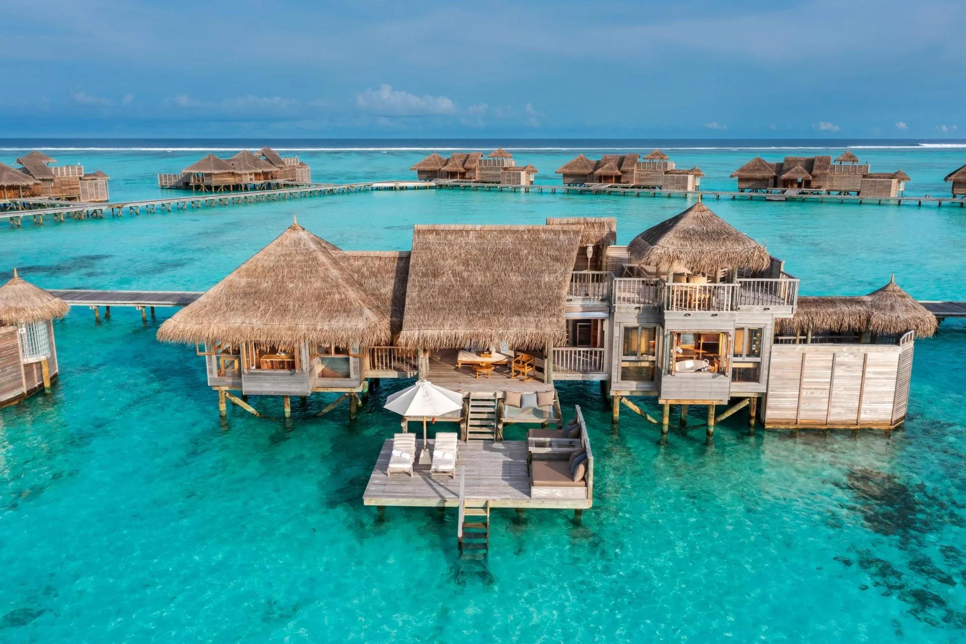 Aerial view of an Overwater Villa Suite at Gili Lankanfushi, its separate shower linked by the resort's signature semi-open-air walkway