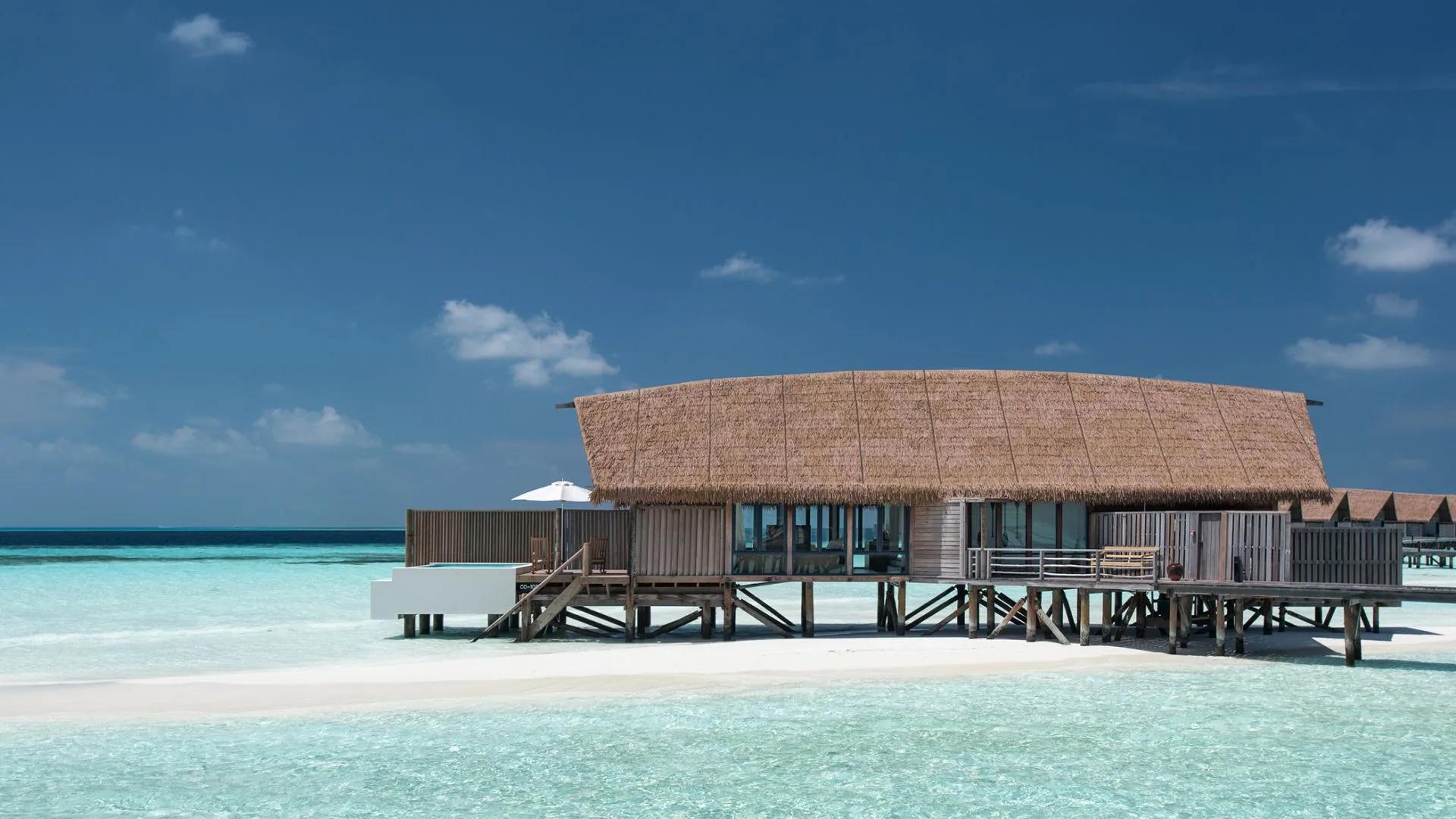 A One-Bedroom Water Villa with Pool, its private plunge pool and shaded deck set over the open lagoon