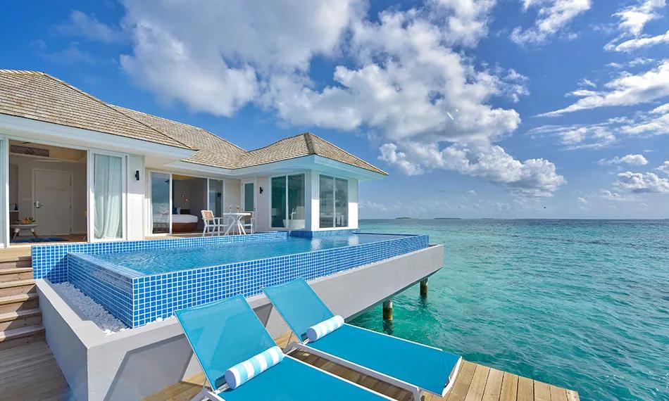 An overwater pool villa's private infinity-edge pool and sun loungers, built out over the lagoon