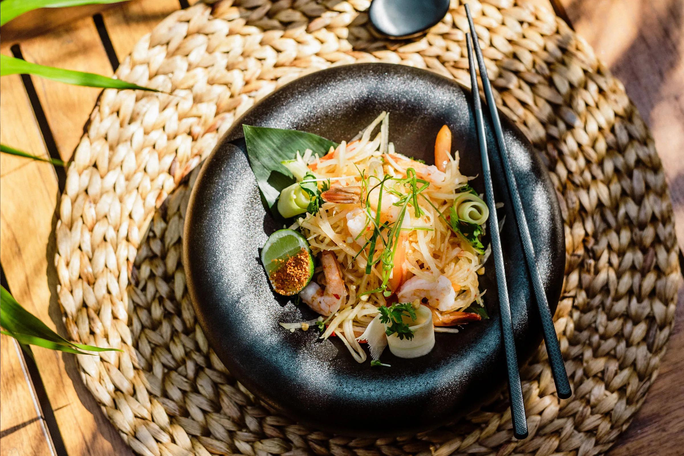 A shrimp and green papaya salad plated with chilli and herbs, served at Bamboo restaurant