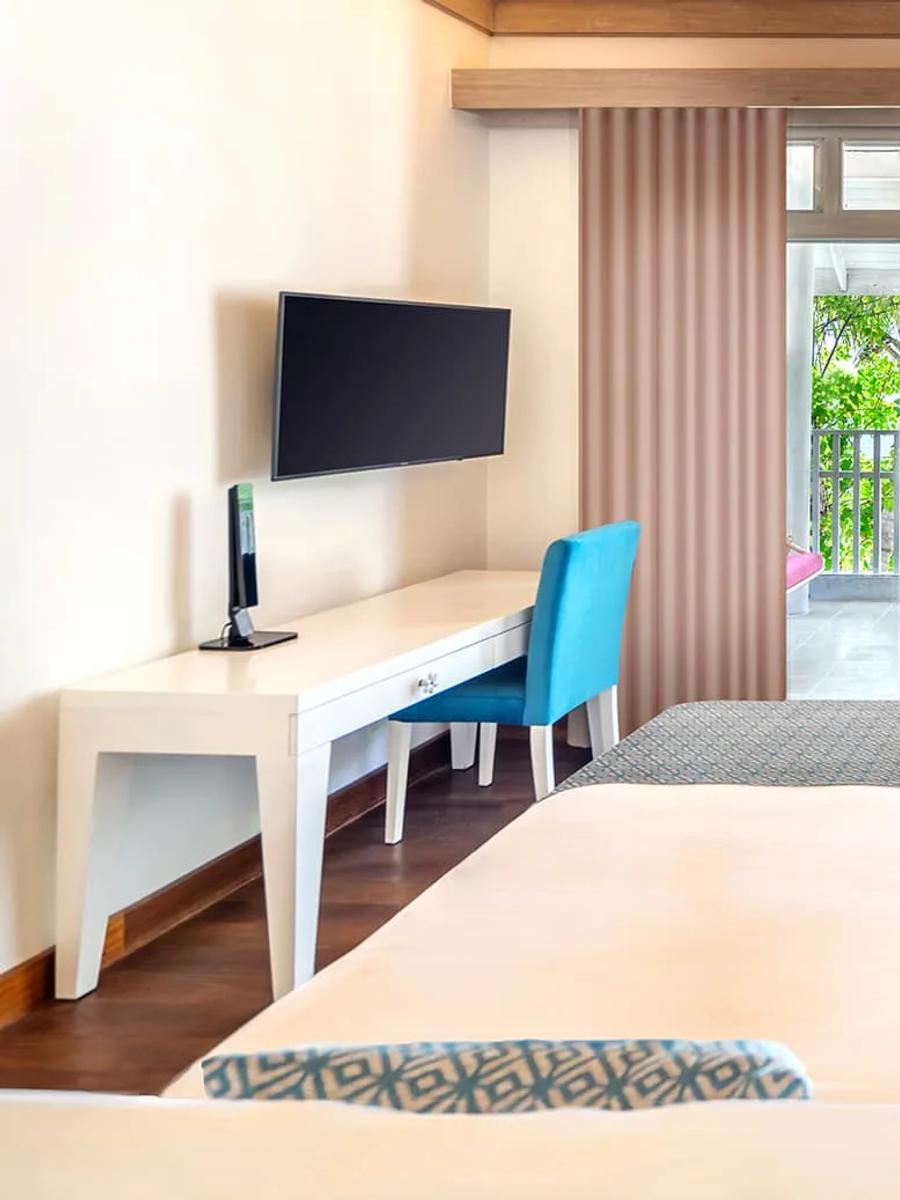 The bedroom of a Beach Duplex Suite with Private Pool, with a sea-facing balcony beyond