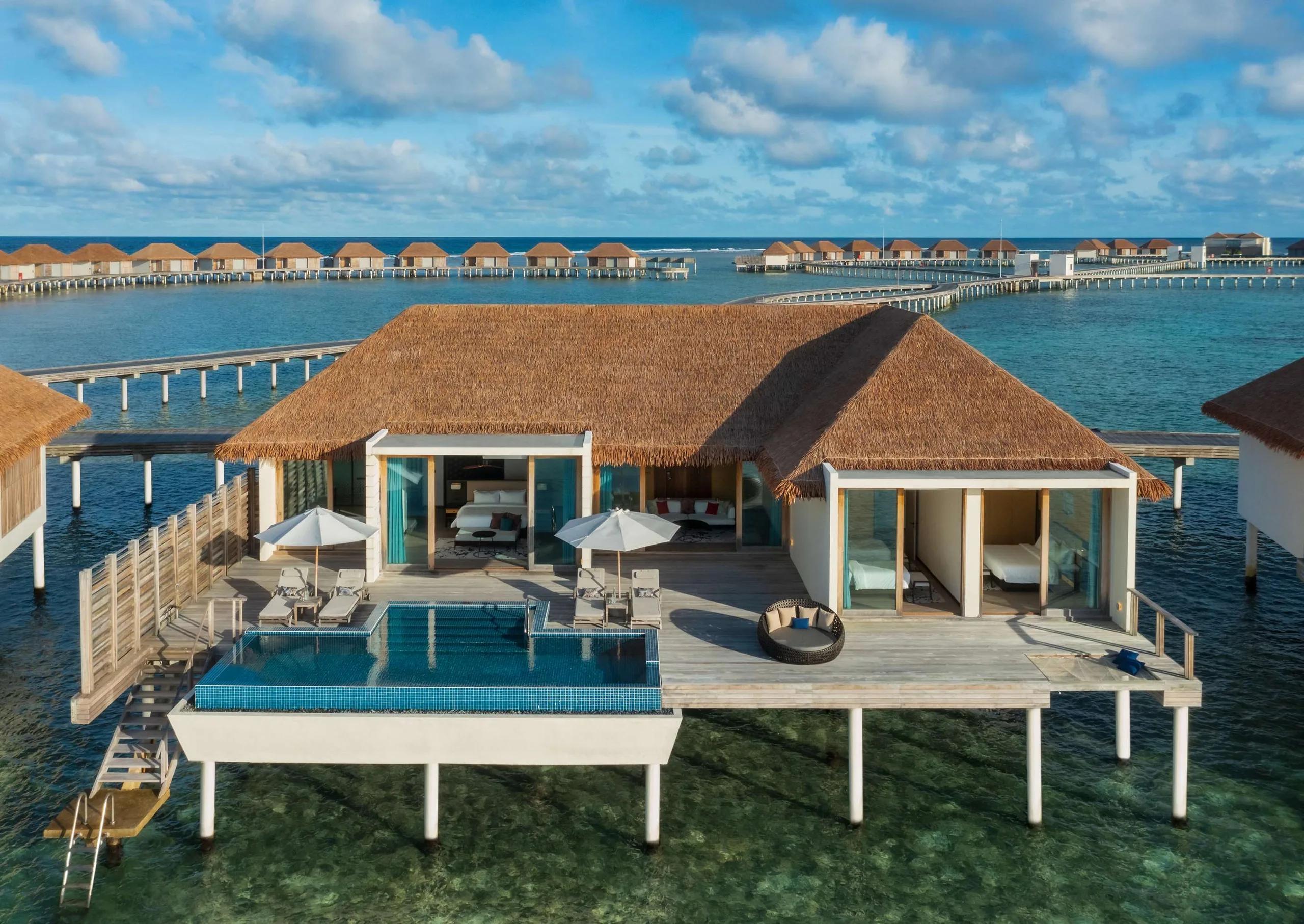 A Three Bedroom Overwater Villa at Radisson Blu Resort Maldives, its wide pool deck stepping down toward the lagoon at sunrise