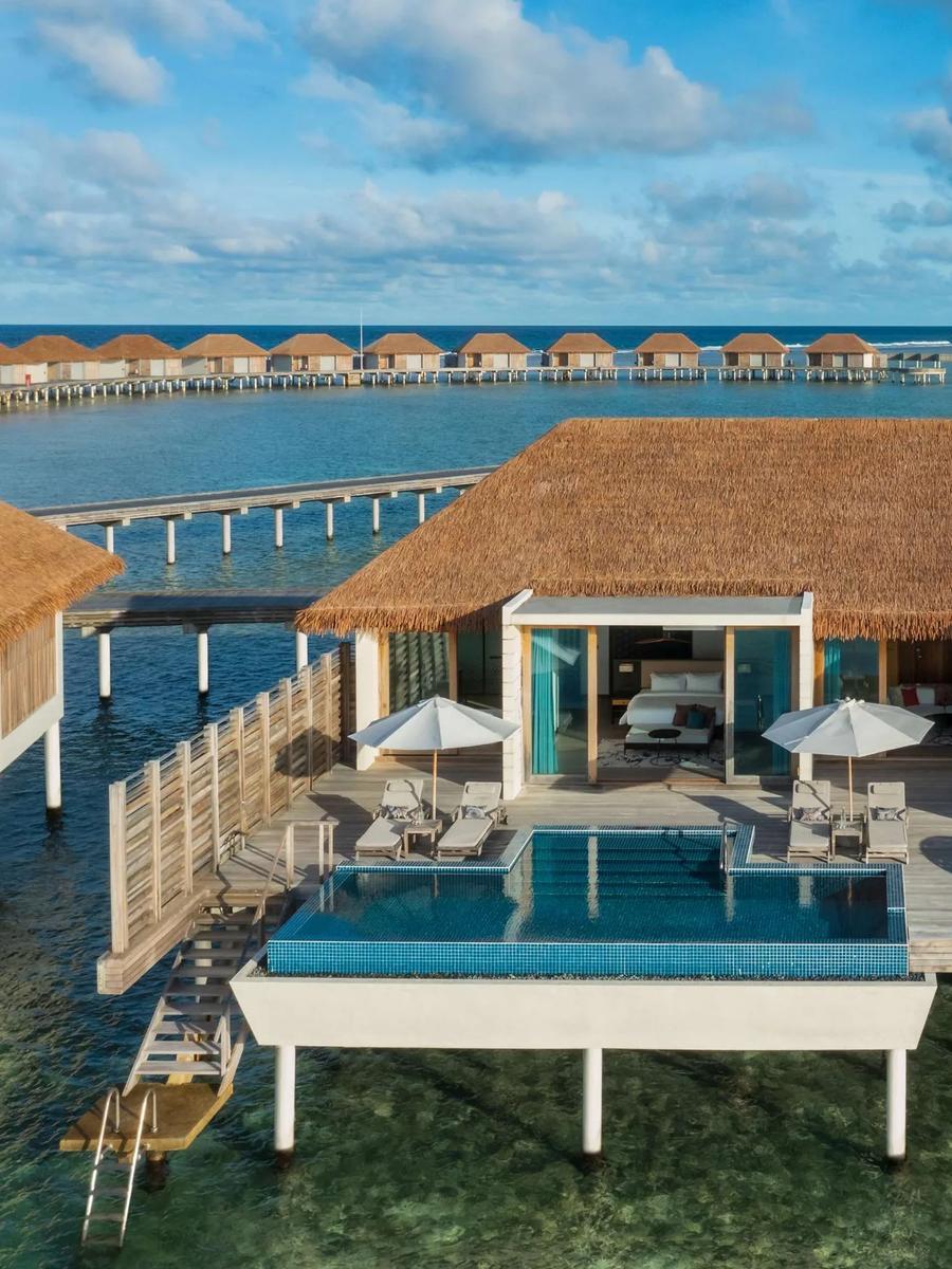 A Three Bedroom Overwater Villa at Radisson Blu Resort Maldives, its wide pool deck stepping down toward the lagoon at sunrise