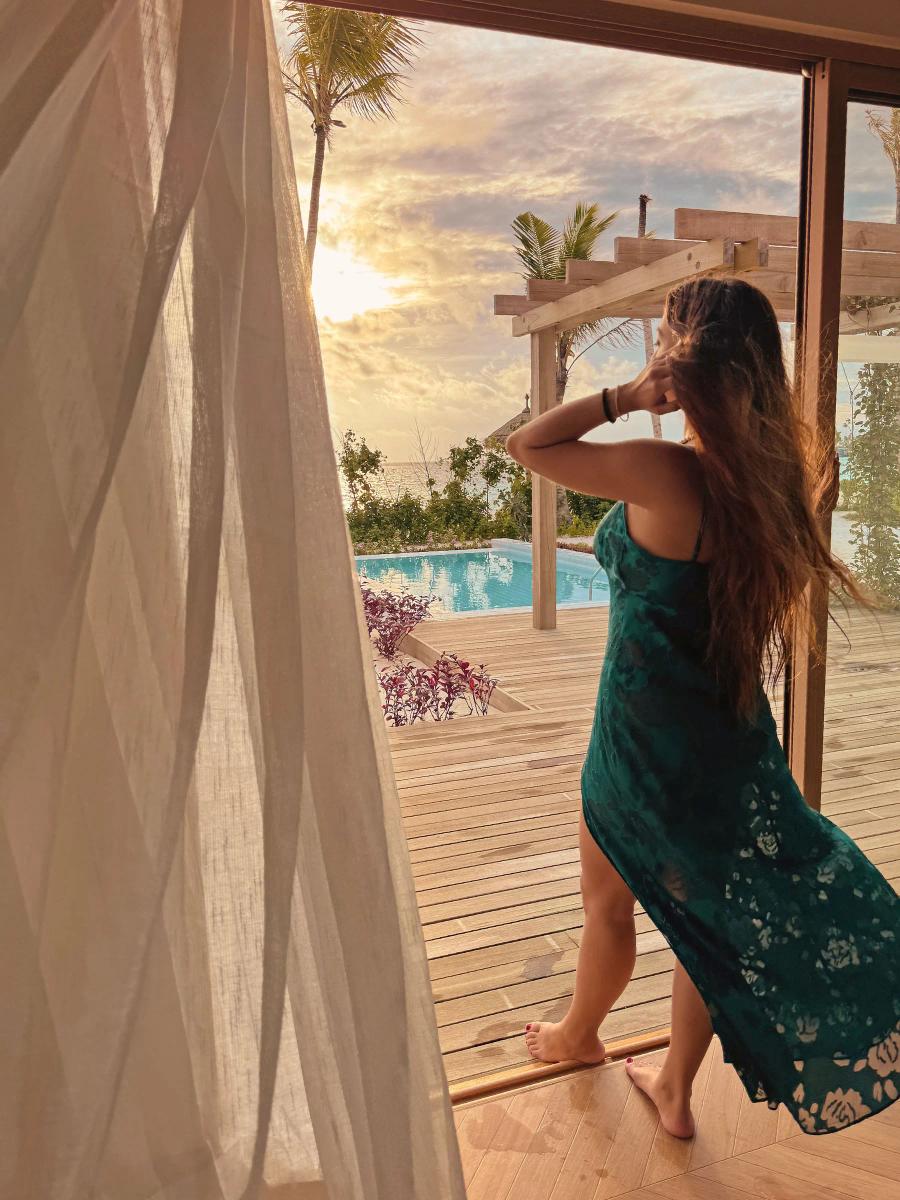 A guest steps out onto the terrace beside the Beach Residence's private plunge pool at sunset