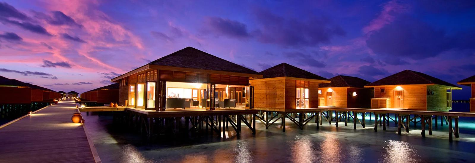 Duniye Spa's overwater treatment pavilion lit at dusk