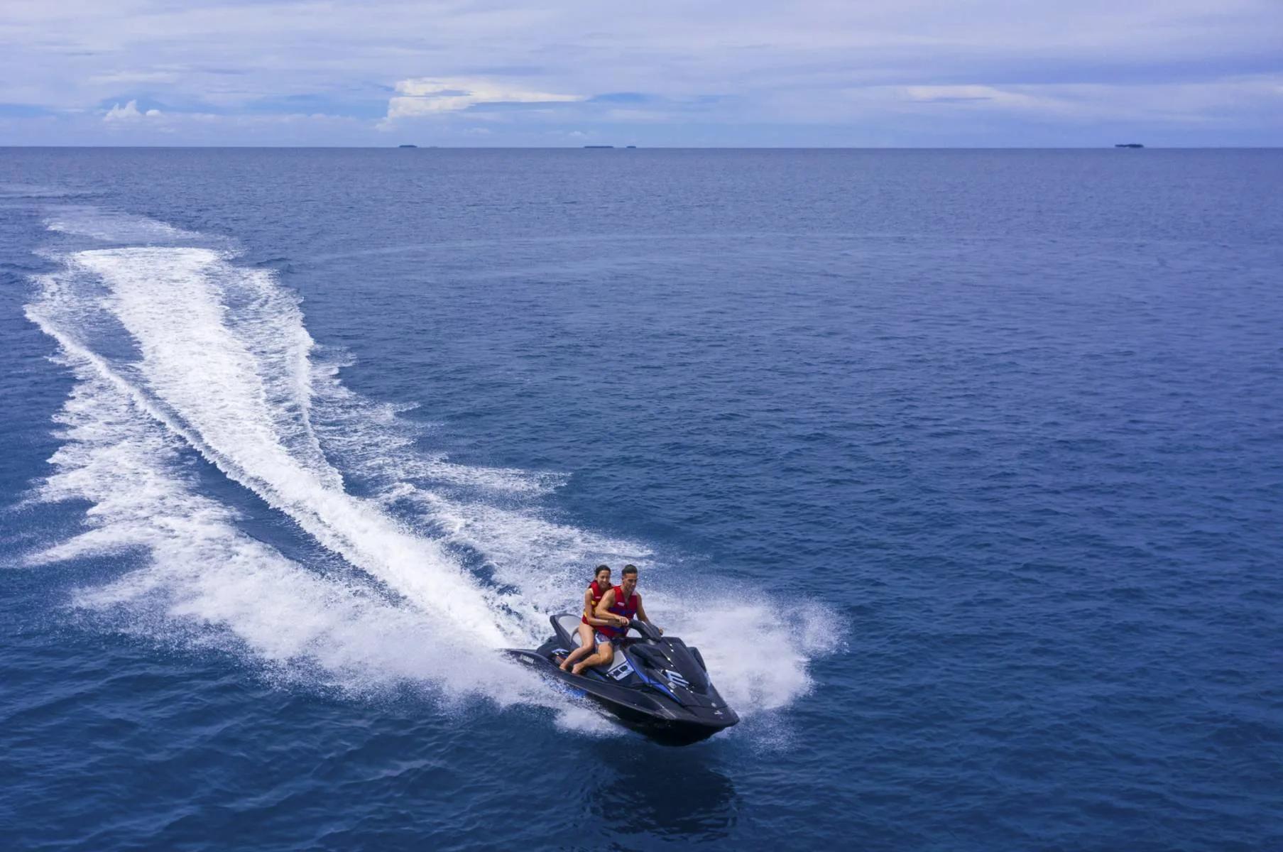 A couple riding a jet ski across the lagoon