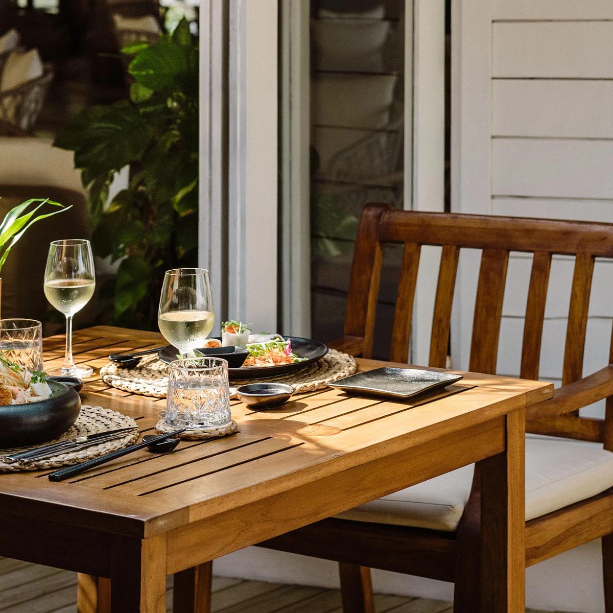 An intimate two-person table set with white wine and small plates on a quiet deck, representative of Iru Fushi's private dining settings — dedicated Cellar photography to follow