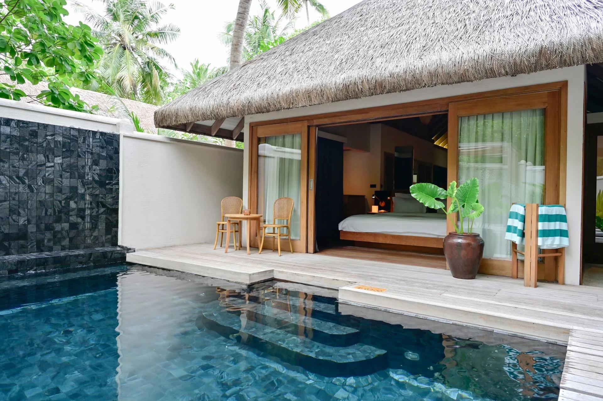 Private plunge pool of the Grand Premier Beach Villa with Pool, black-tiled wall and bedroom visible through open doors