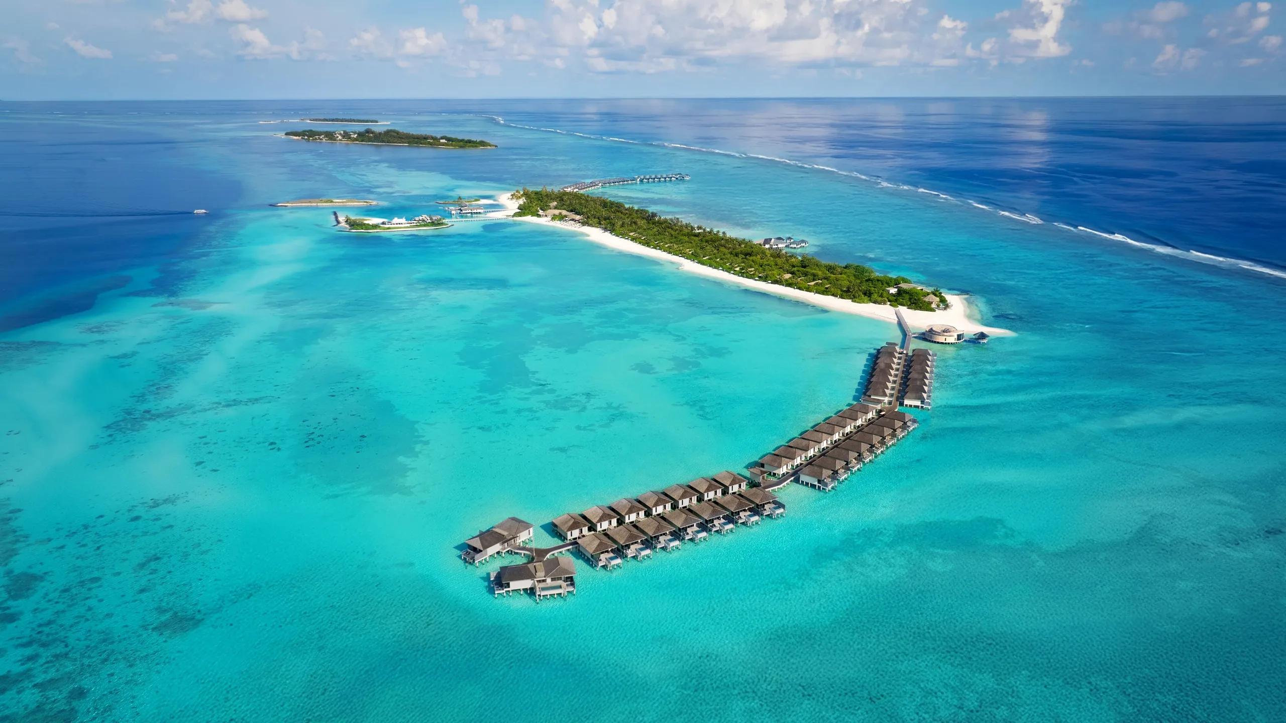 Aerial view of Le Méridien Maldives Resort & Spa's overwater villas fringing Thilamaafushi Island, Lhaviyani Atoll