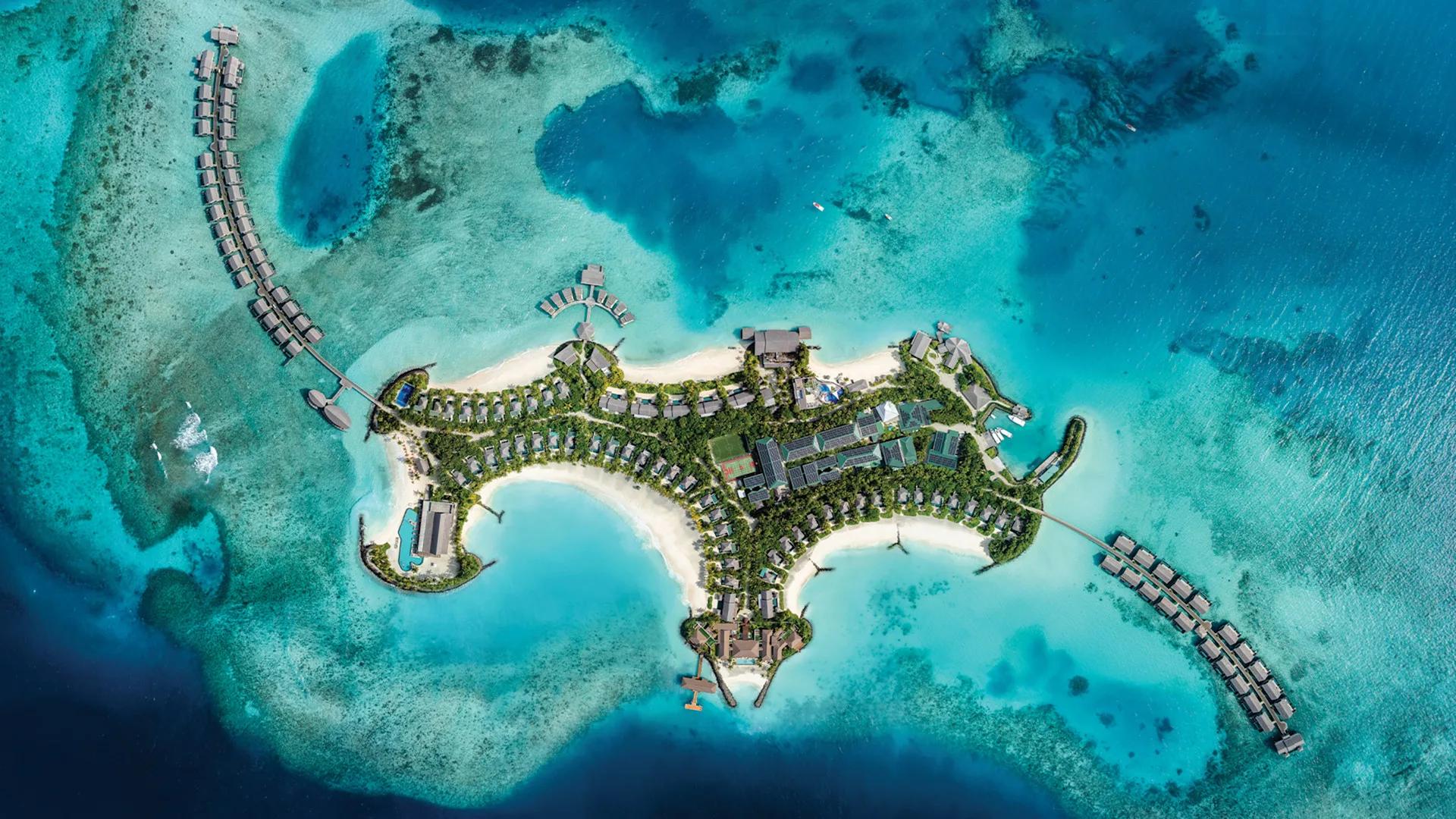 A top-down aerial view of Hilton Maldives Amingiri Resort & Spa's overwater villas and lagoon in North Malé Atoll