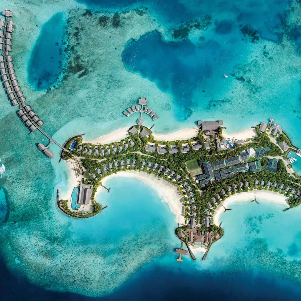A top-down aerial view of Hilton Maldives Amingiri Resort & Spa's overwater villas and lagoon in North Malé Atoll