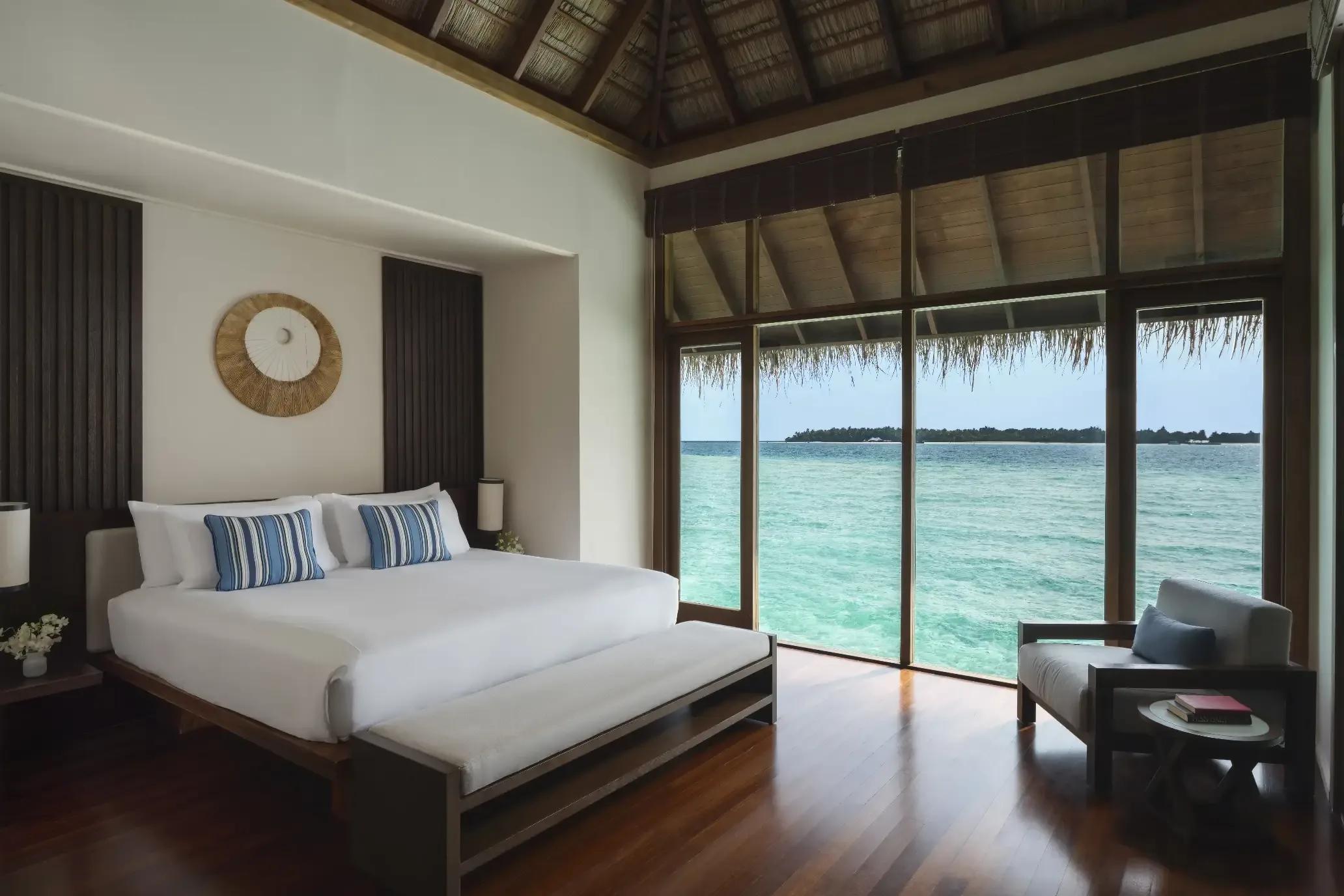 The ocean-facing bedroom of a Grand Water Villa with Pool at Conrad Maldives Rangali
