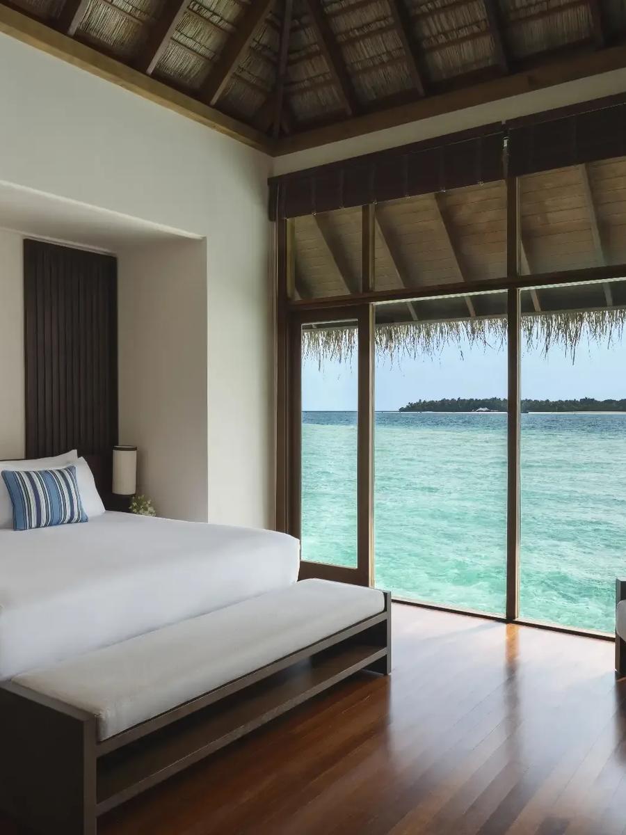The ocean-facing bedroom of a Grand Water Villa with Pool at Conrad Maldives Rangali