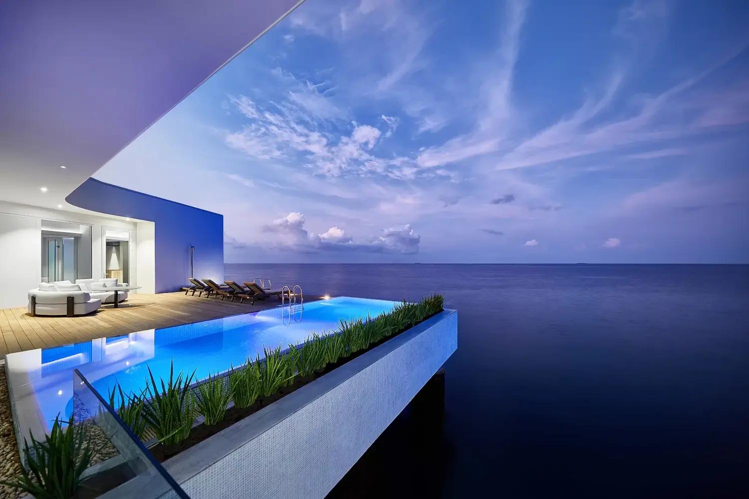The Muraka's outdoor deck and infinity pool extending over the ocean at dusk