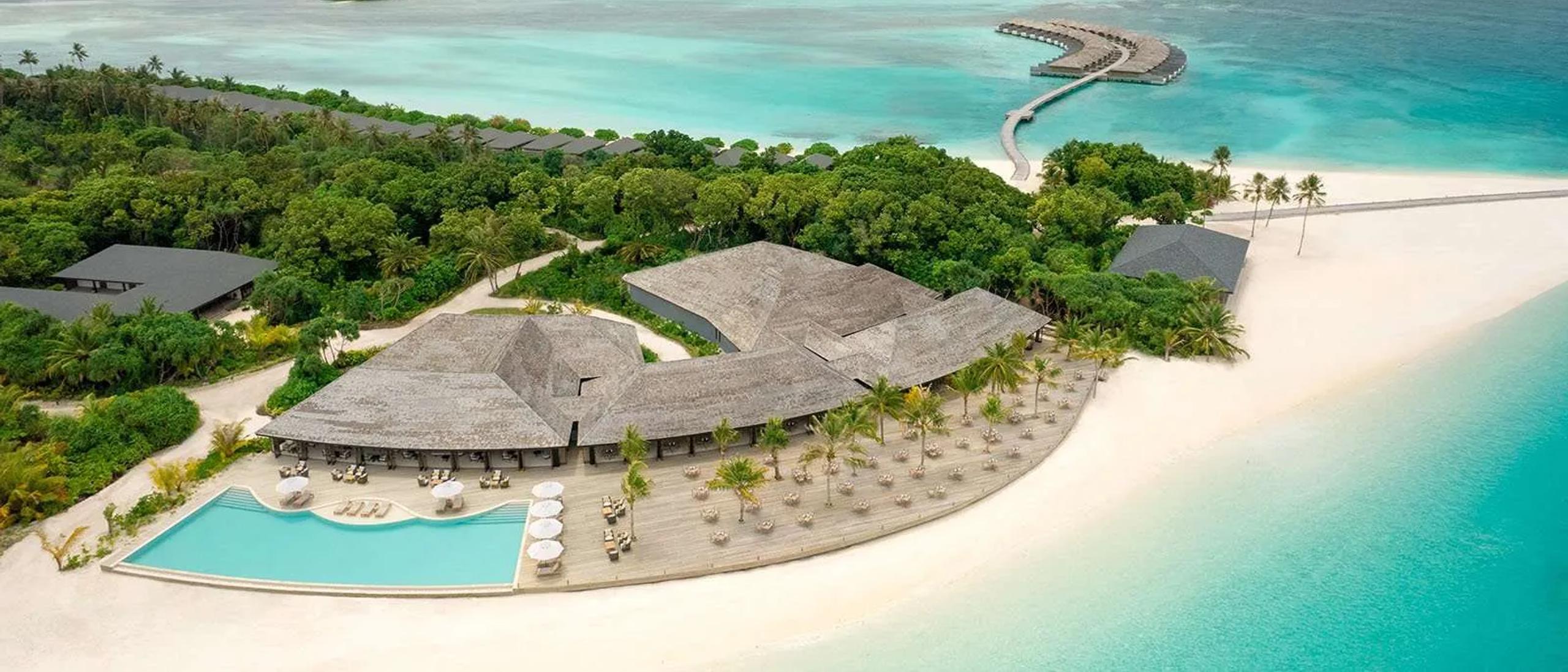 Aerial view of Jawakara's Mabin Island pool deck and restaurant pavilion, with a jetty leading out to a cluster of overwater villas