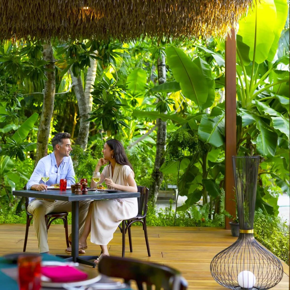 A couple seated at Phat Chameleon, the resort's plant-forward restaurant