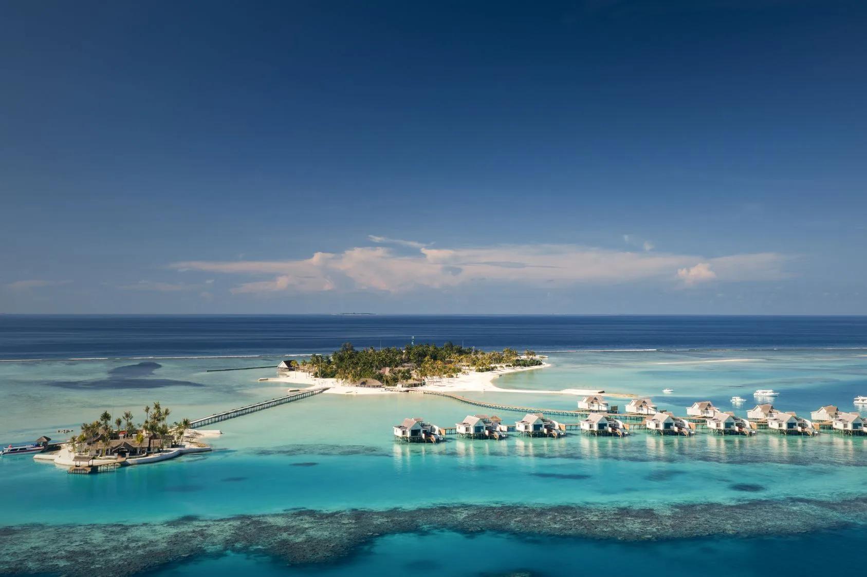 Aerial view of RAH GILI Maldives' island in South Malé Atoll, showing its overwater villa row and jetty