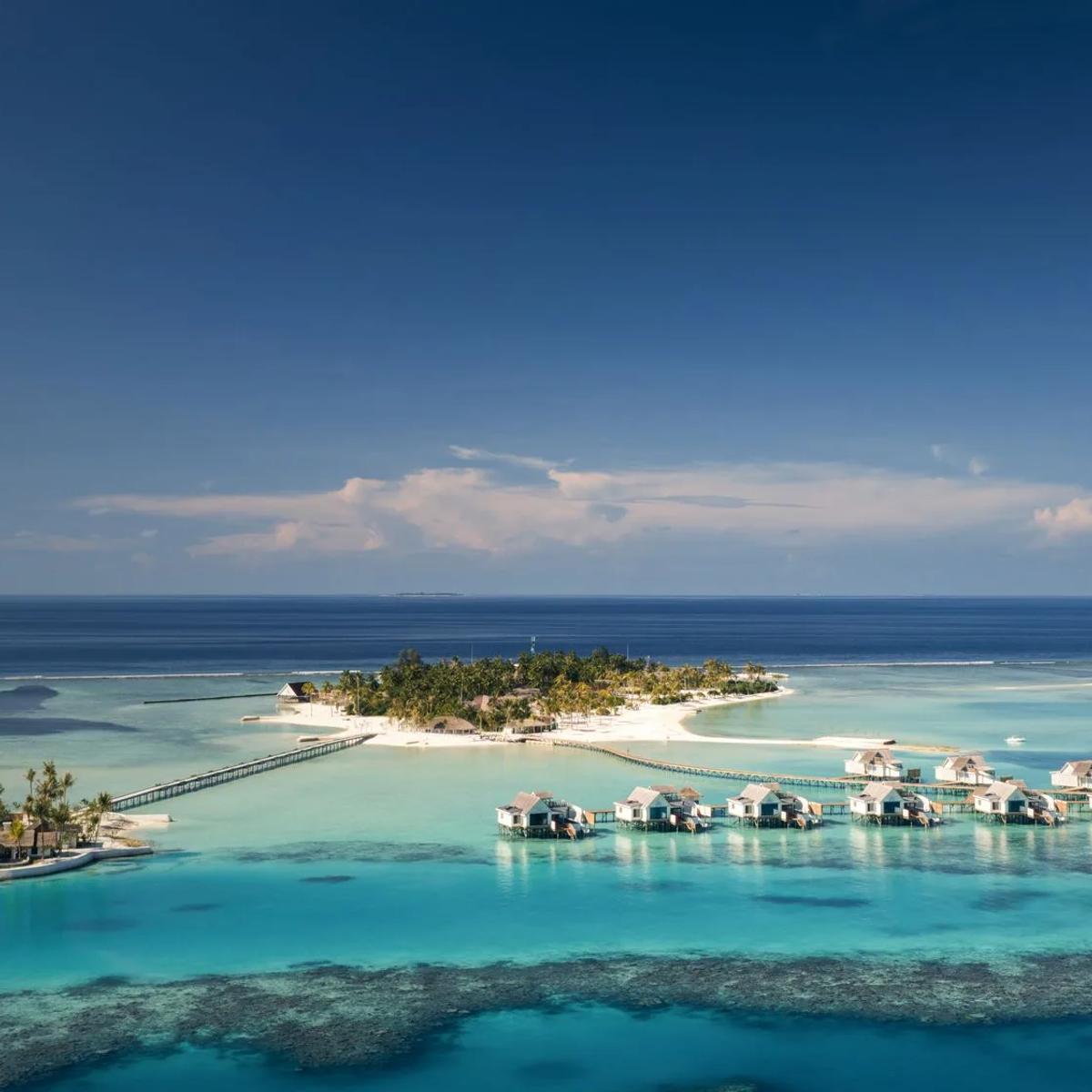 Aerial view of RAH GILI Maldives' island in South Malé Atoll, showing its overwater villa row and jetty