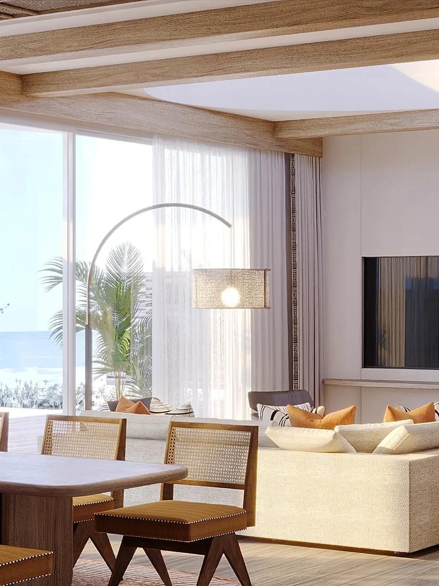 An open-plan living room in a Two Bedroom Water Residence, floor-to-ceiling windows facing the sea