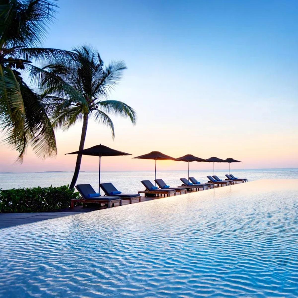 Senses Lounge and Bar's infinity pool and loungers at sunset