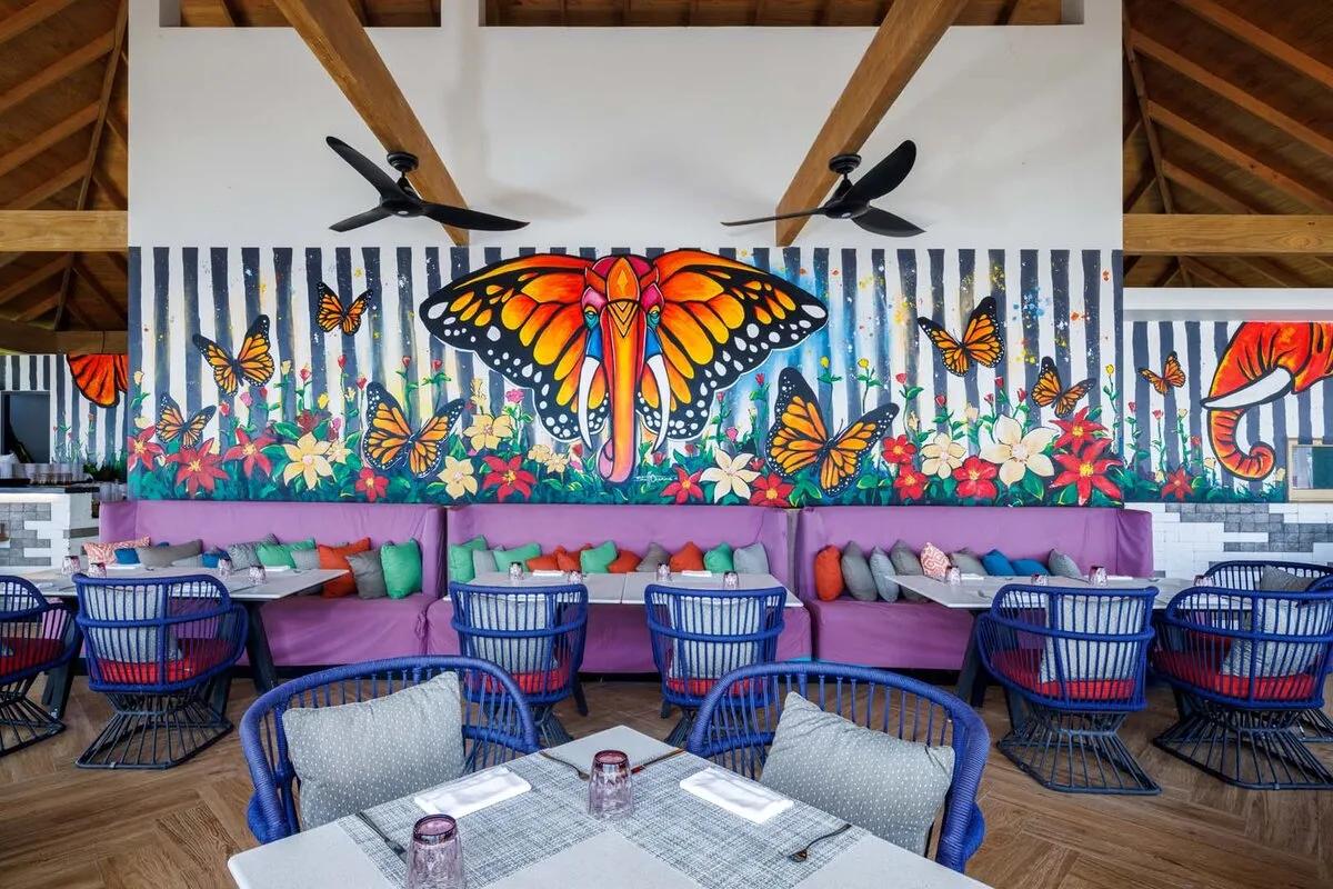 The Elephant and The Butterfly's namesake mural — an elephant with butterfly wings amid monarch butterflies and flowers — painted across the dining room wall