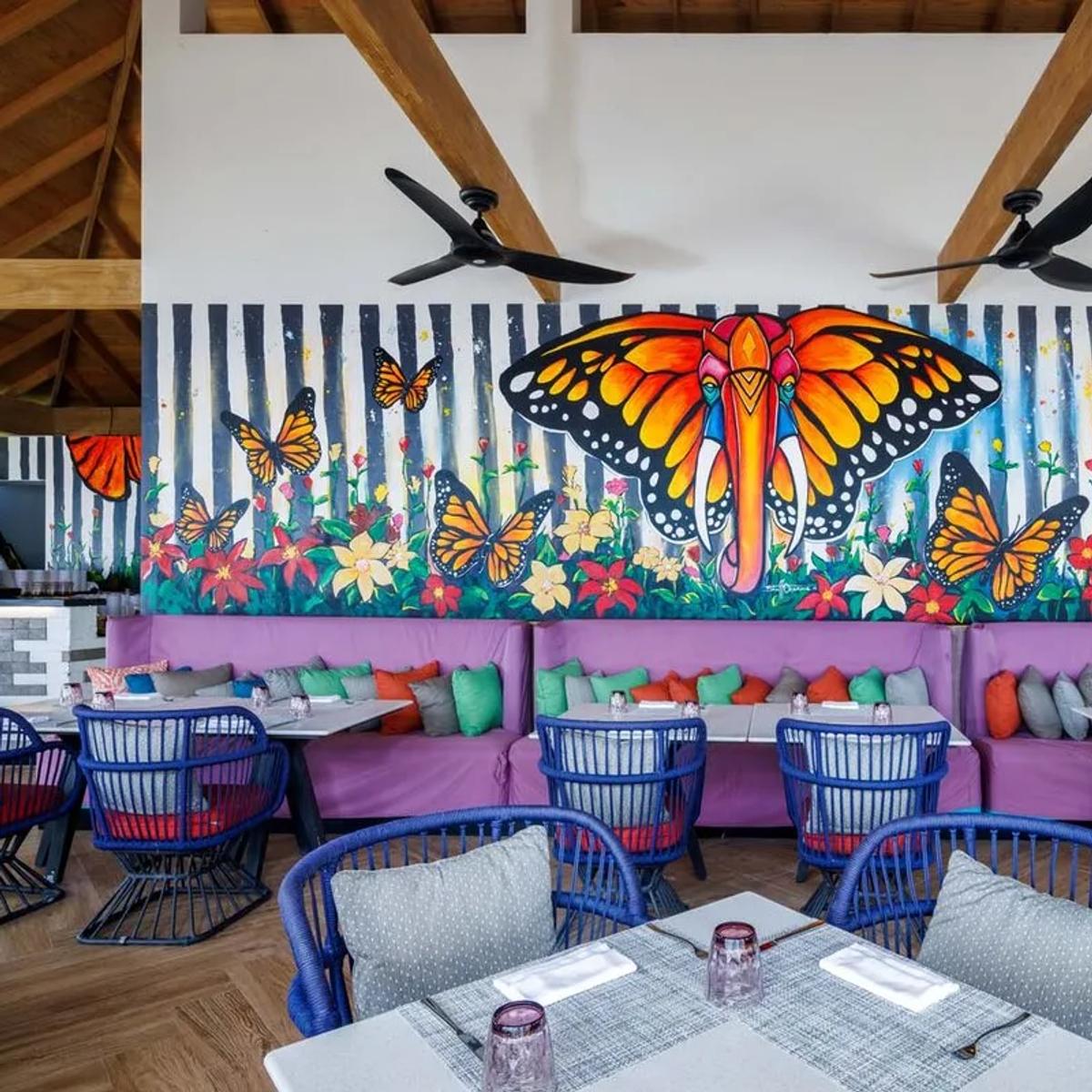 The Elephant and The Butterfly's namesake mural — an elephant with butterfly wings amid monarch butterflies and flowers — painted across the dining room wall