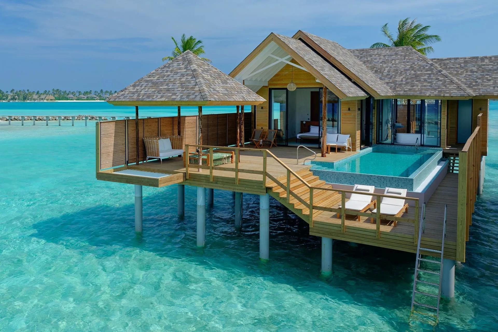 The infinity pool of a Deluxe Water Pool Villa reaching toward the open lagoon