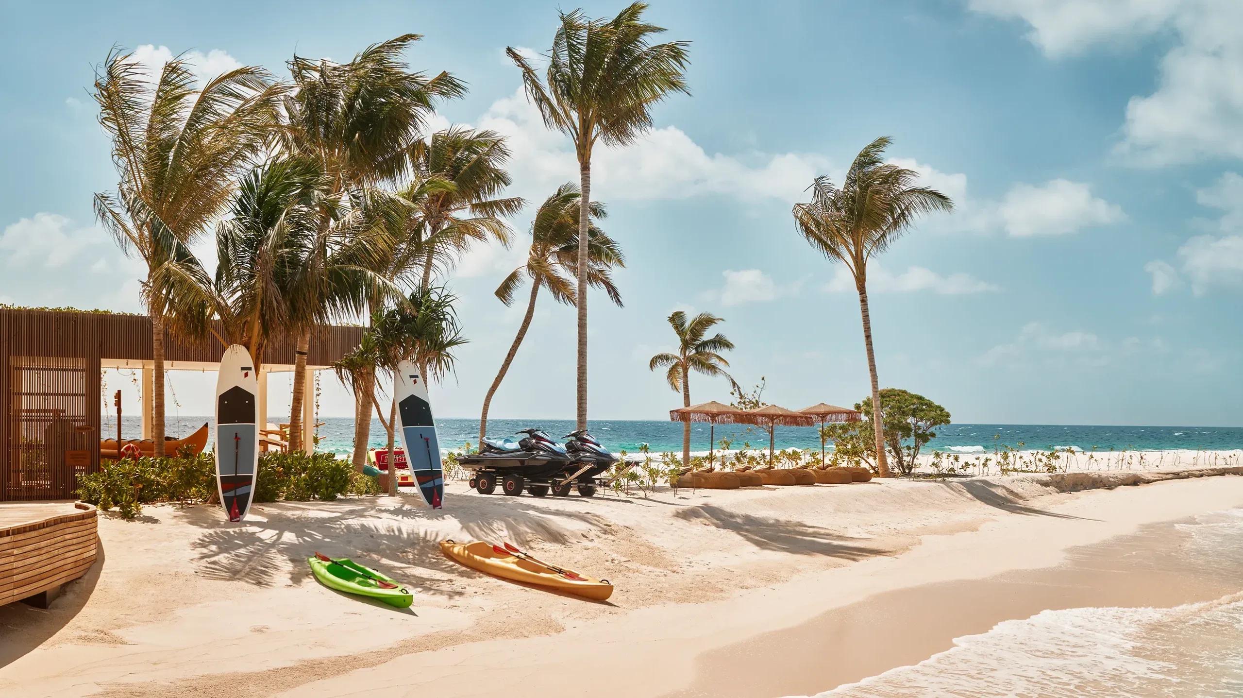 A stand-up paddleboard resting at the water's edge on .Here's beach, lagoon stretching toward the reef