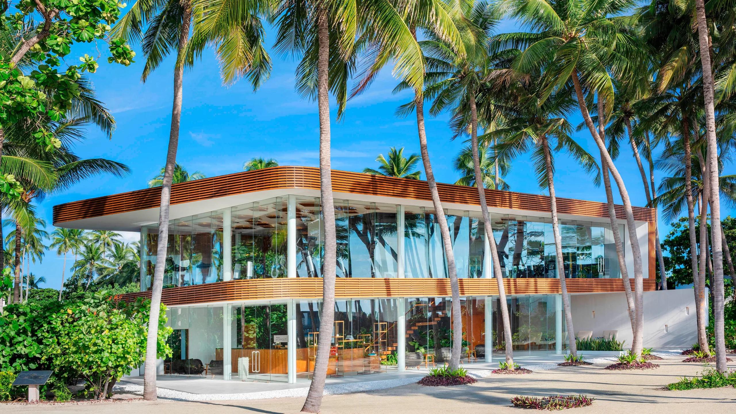 The glass-walled WestinWORKOUT fitness studio among the palms, exercise equipment visible inside