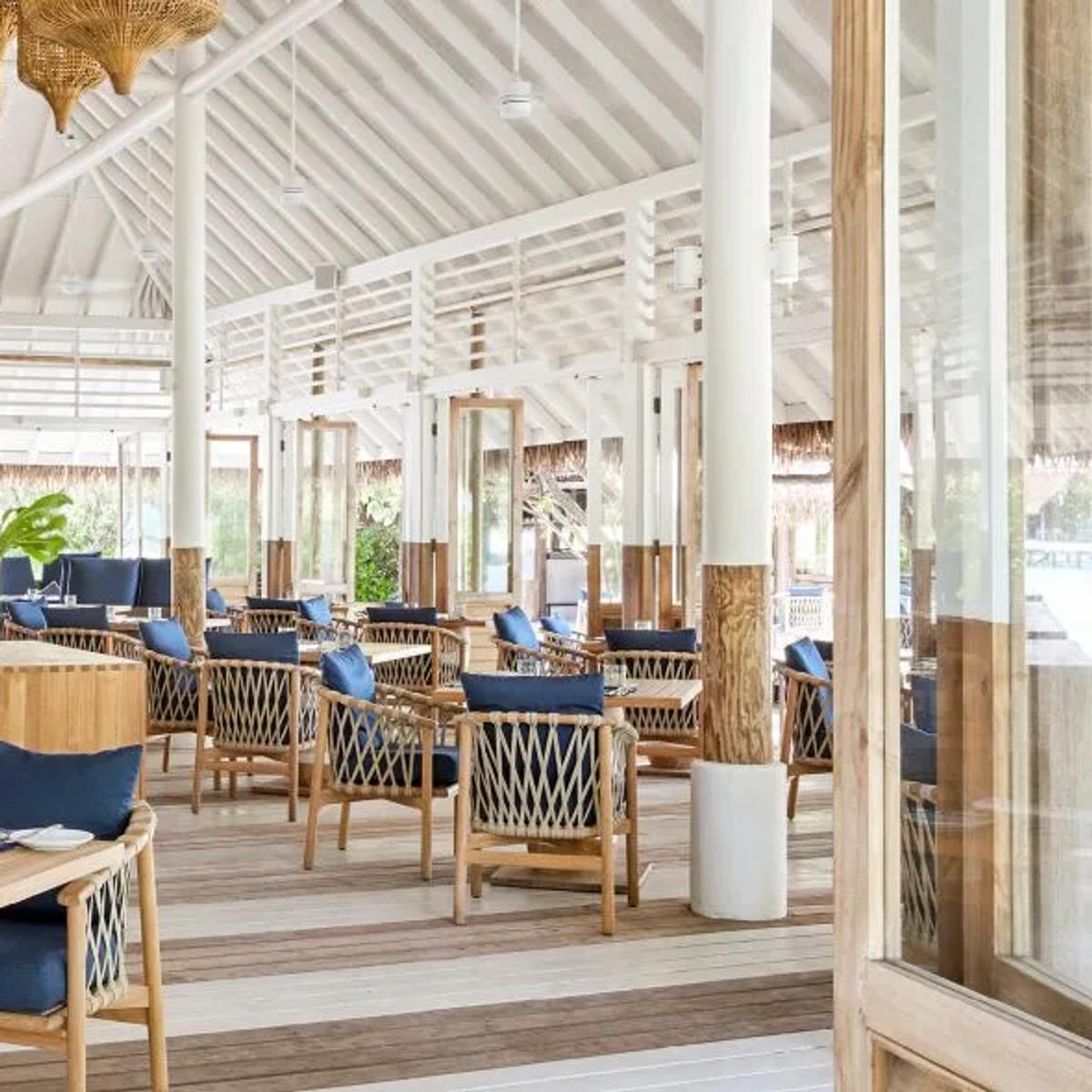Ufaa's open-air dining room, with woven rattan pendant lights over tables set for service