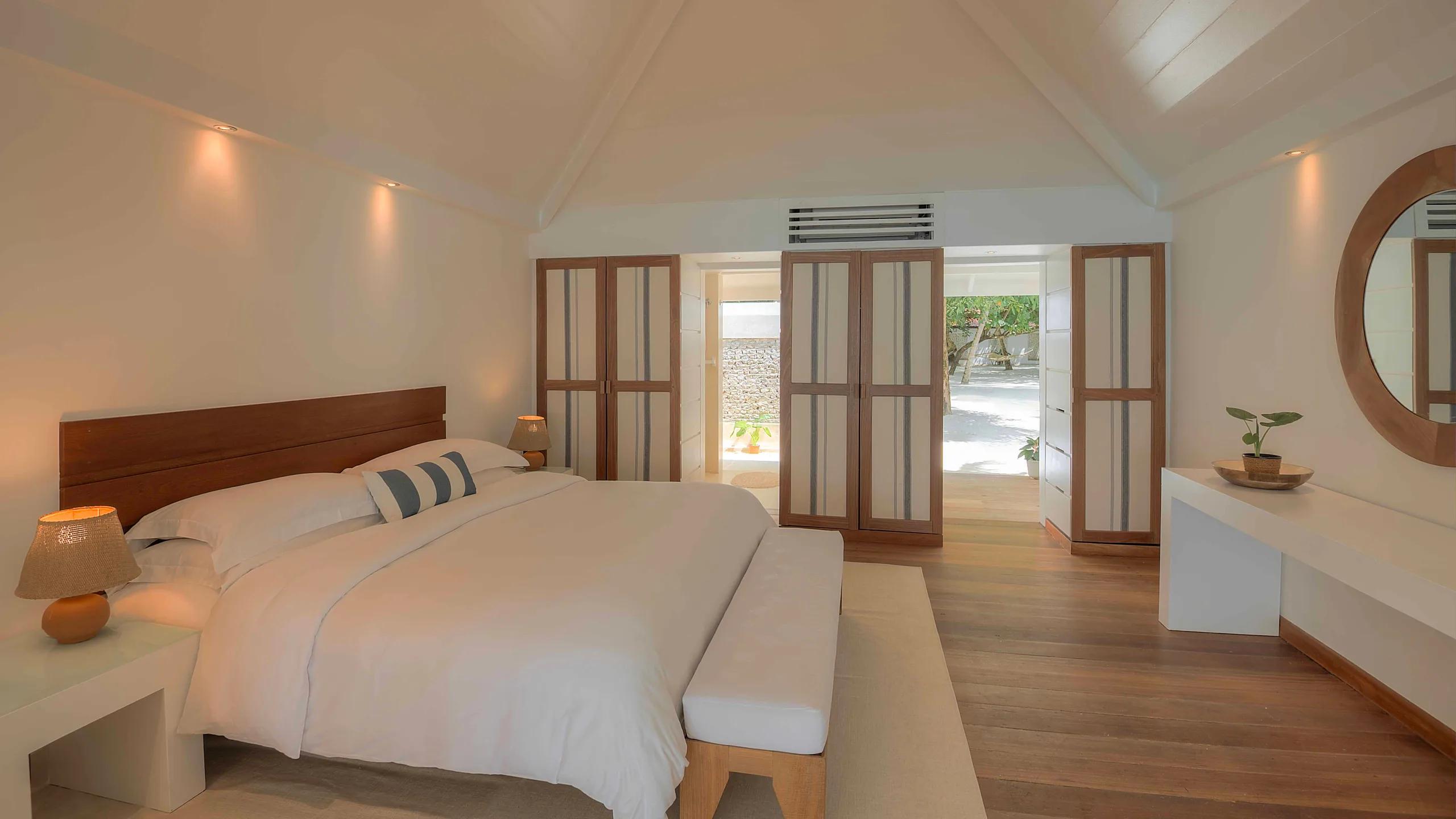 Bedroom interior of a Beach Front Villa at Diamonds Athuruga, opening onto its private veranda